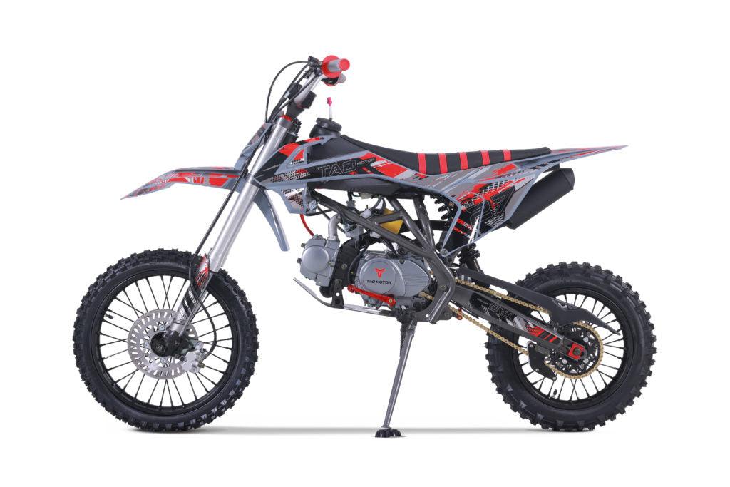 Gray and red dirt bike with off-road tires, side view on white background
