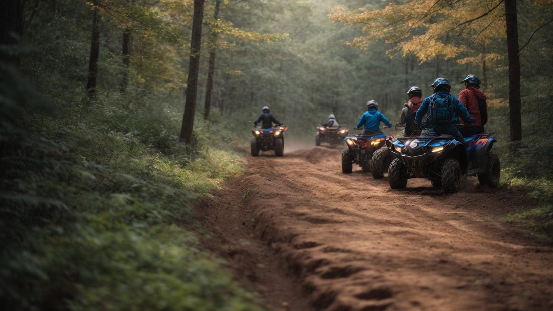 Group of people riding ATVs on a forest trail, wearing helmets and outdoor gear.