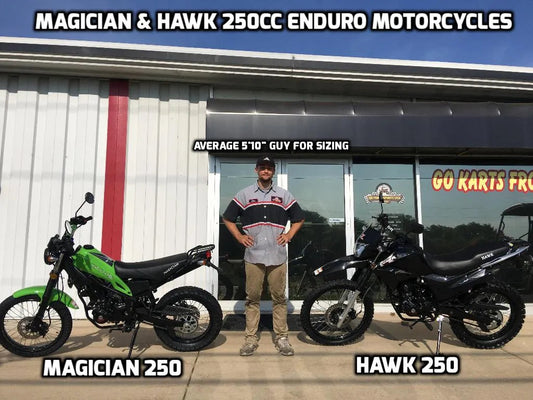 Magician 250 and Hawk 250 enduro motorcycles side by side outdoors with a person for scale.