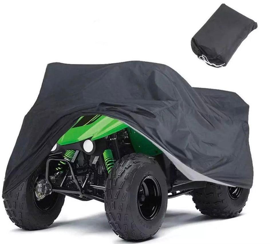 Green ATV partially covered by a black protective cover with storage bag nearby