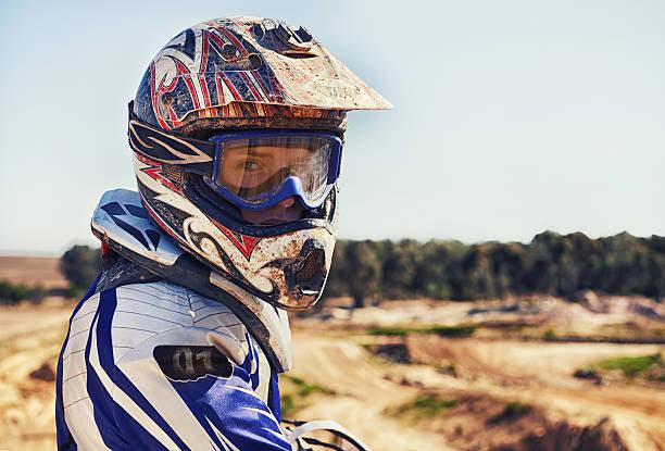 Youth in motocross helmet and gear at outdoor dirt bike track, Q9 PowerSports USA