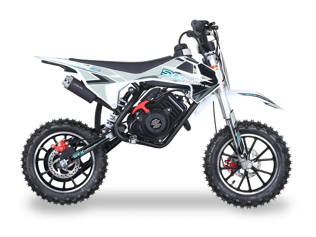 White and black mini dirt bike with knobby tires and SYX branding, side view