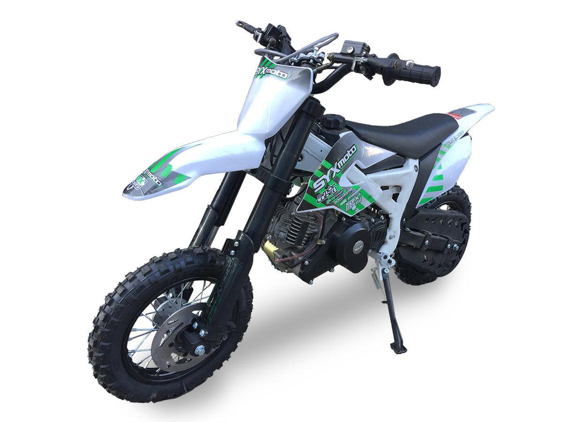 White and green kids dirt bike with knobby tires and kickstand on white background