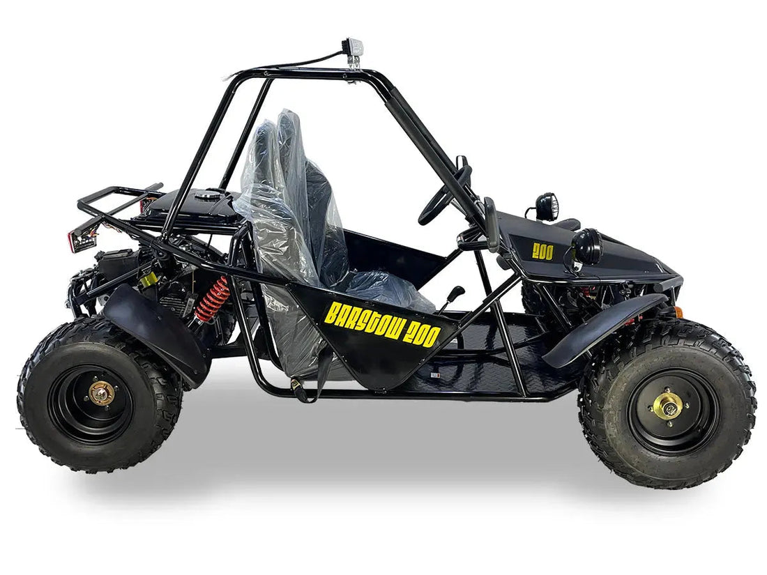 Black off-road go-kart with roll cage, large tires, and Barstow 200 yellow logo