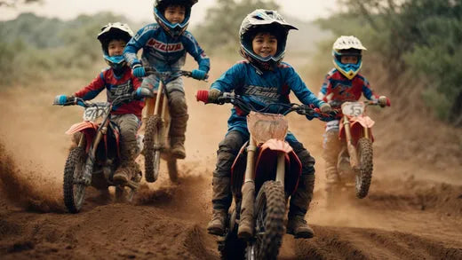 Kids riding dirt bikes outdoors, wearing helmets and racing on a muddy trail