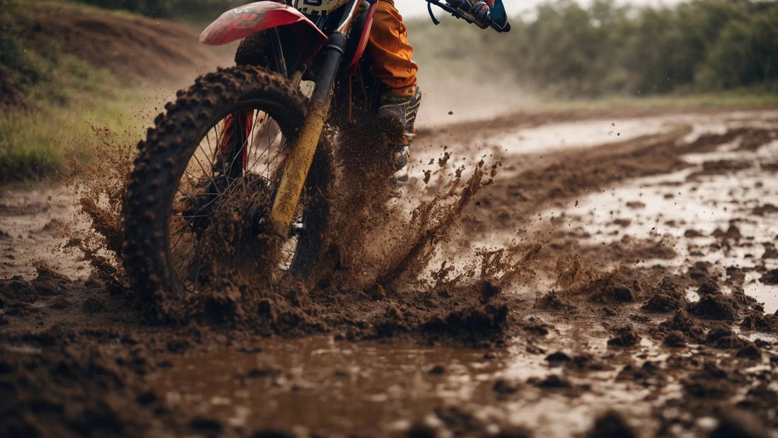 Dirt bike kicking up mud on an off-road trail, showing rugged tire and rider in action