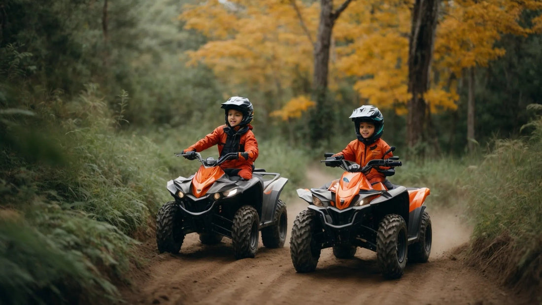 Two kids riding orange youth ATVs on a dirt trail in a forest with autumn foliage