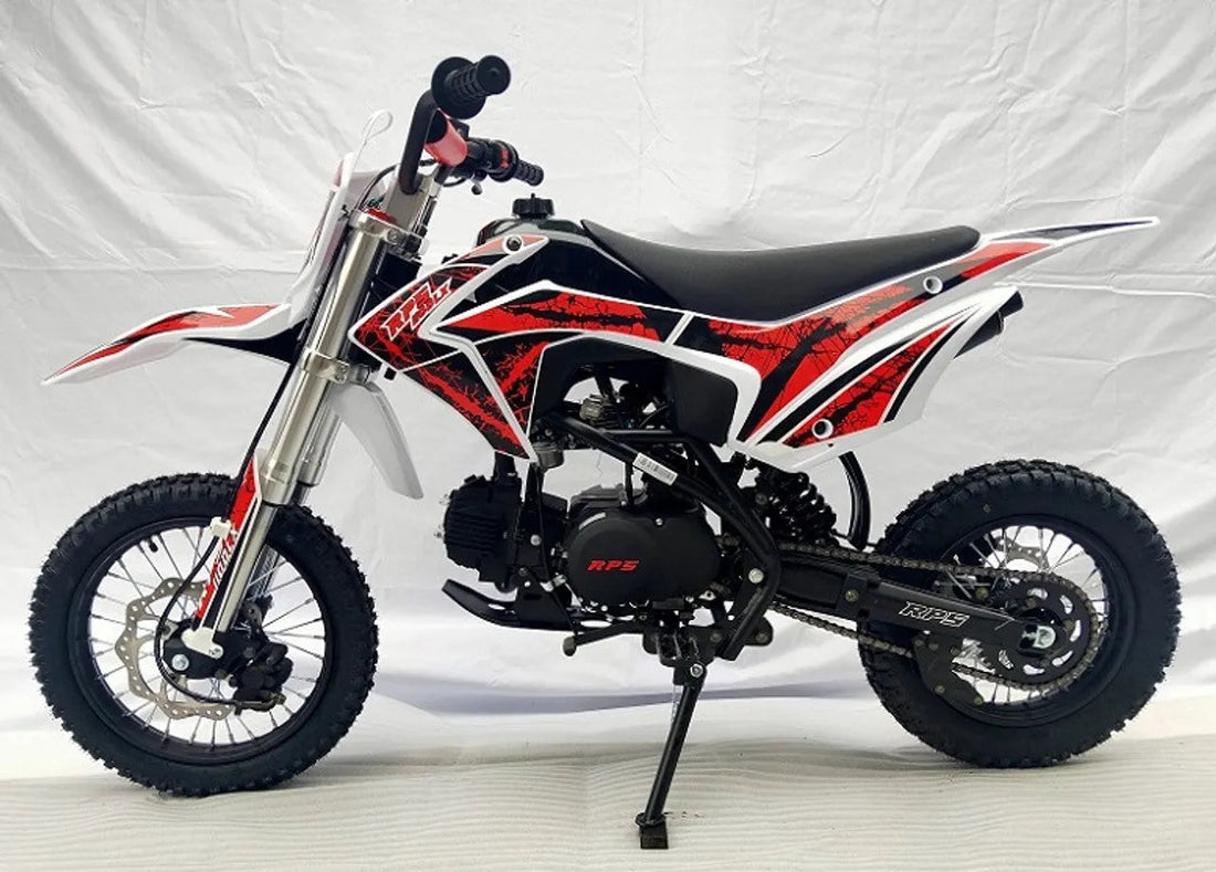 Red and black youth dirt bike with off-road tires and sporty graphics, side view