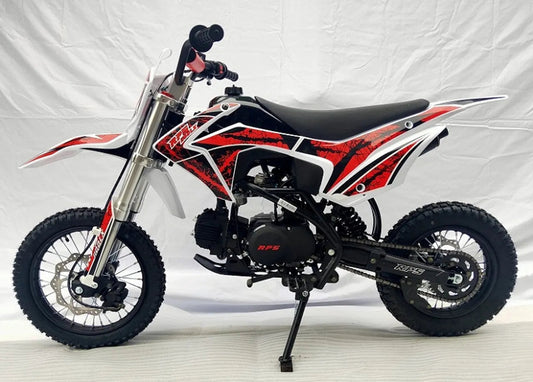 Red and black youth dirt bike with off-road tires and sporty graphics, side view