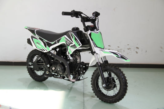 Green and white kids dirt bike with off-road tires in a studio setting
