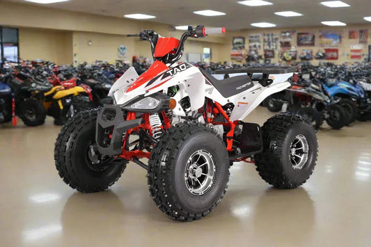 White and red youth ATV with large off-road tires on showroom floor