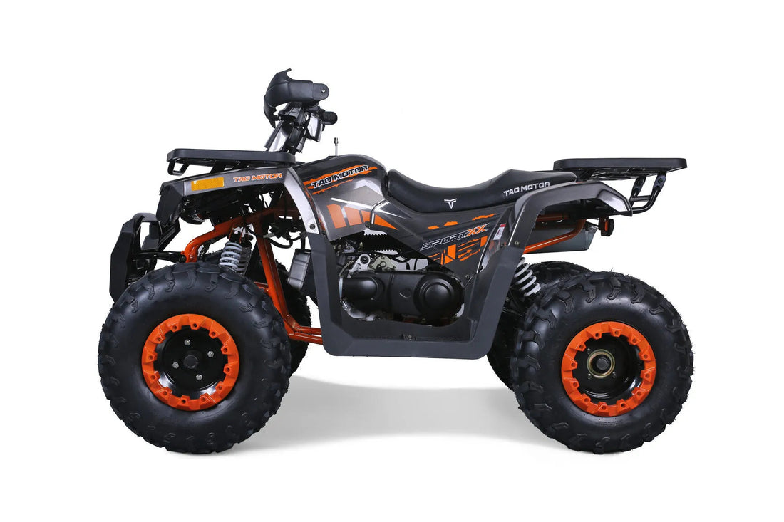 Orange and black sport ATV with rugged tires and front suspension, shown in a studio setting