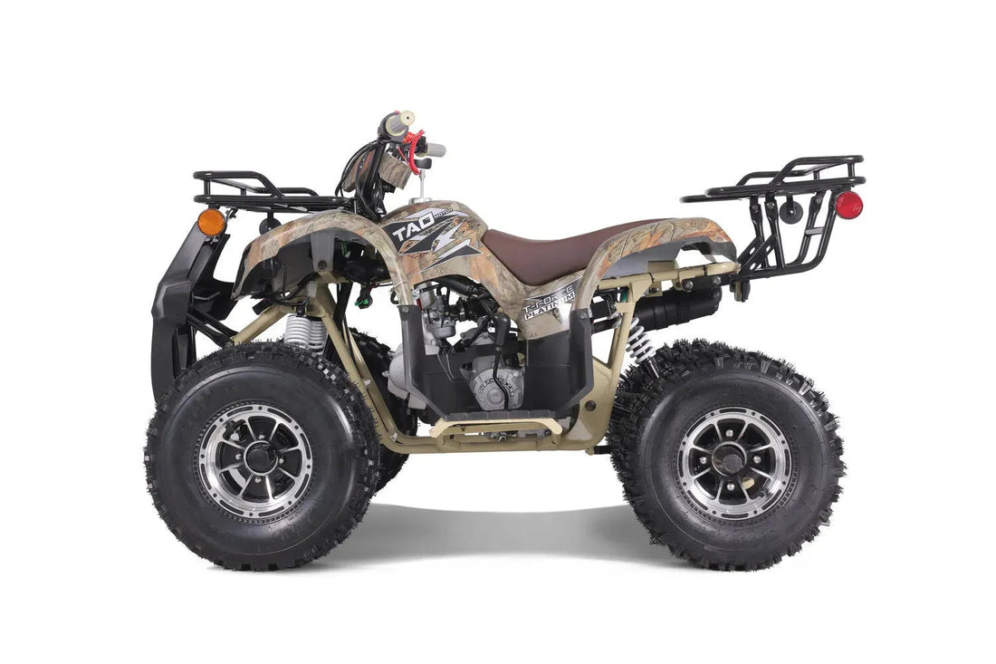 Camo ATV with rugged tires, rear rack, and brown seat on white background