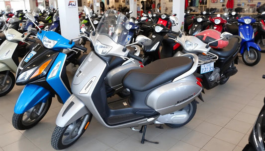 Showroom with multiple scooters and mopeds for sale, including silver and blue models