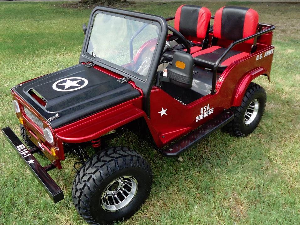 Red youth go-kart styled like a mini army jeep with black seats, shown on grass.