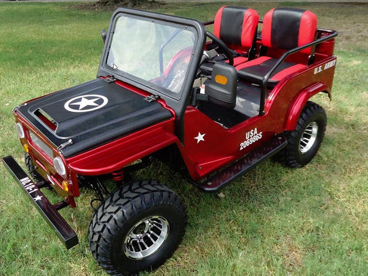 Red kids go-kart styled like a mini military jeep with decals, parked on grass