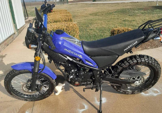 Blue 250cc enduro dirt bike with off-road tires parked on pavement outdoors