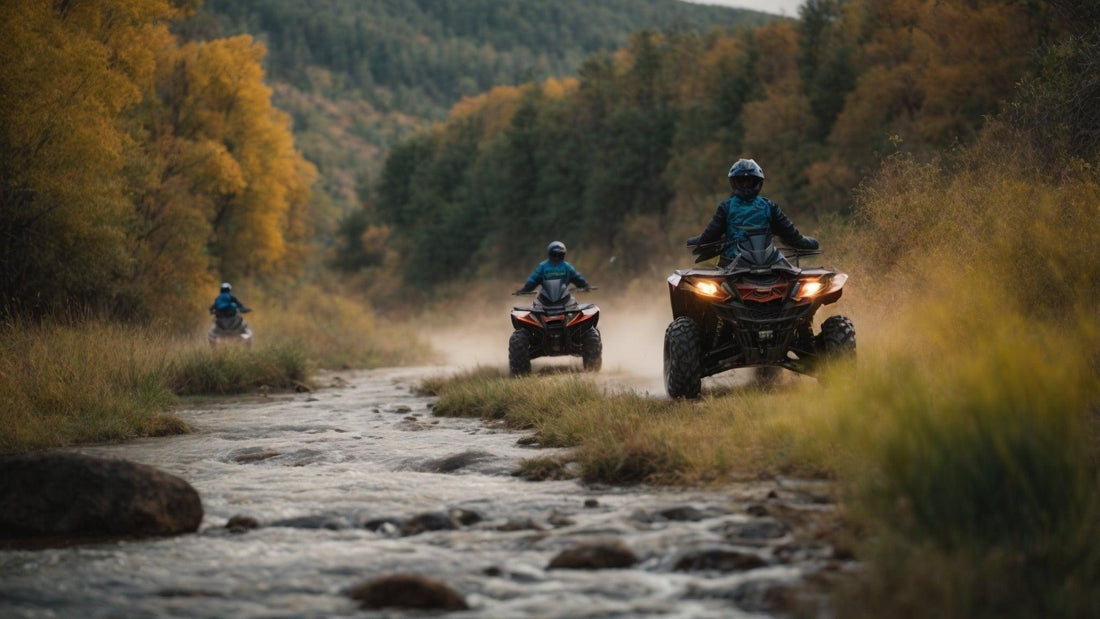 Group riding all-terrain vehicles through a forest trail beside a rocky stream