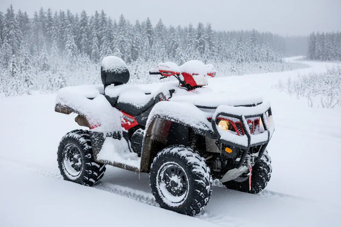 ATV covered in snow parked outdoors on a snowy trail with winter forest background