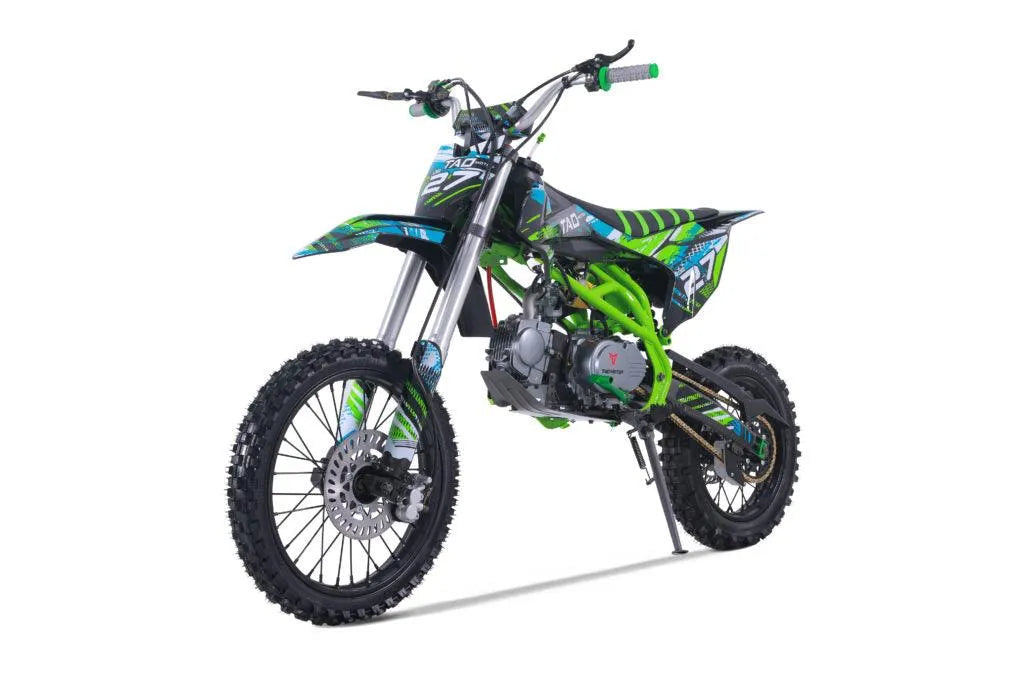 Youth dirt bike in black and green with knobby tires, front disc brake, and graphic decals on white background