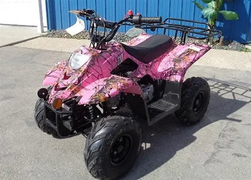 Pink camouflage kids ATV with rugged tires parked outdoors on pavement