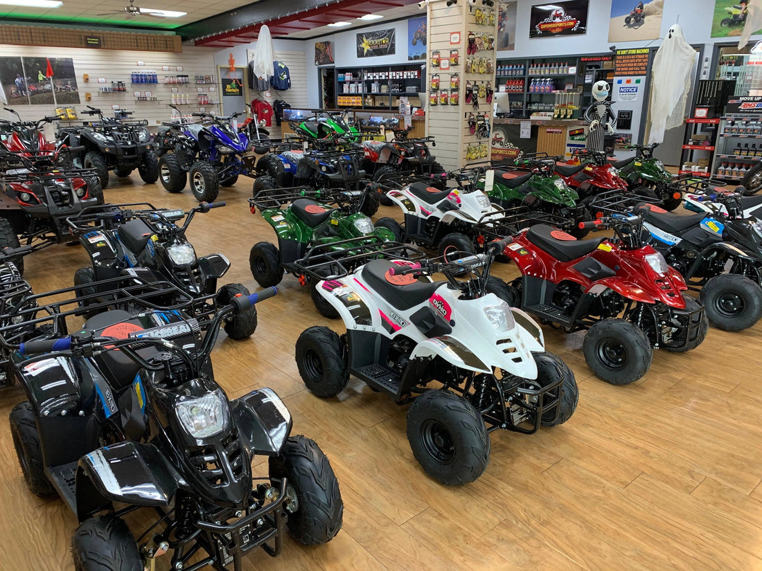 Showroom with various youth and adult ATVs in multiple colors on display