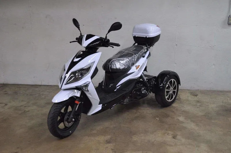 White and black three-wheel scooter with a storage box on the back, parked indoors on concrete floor