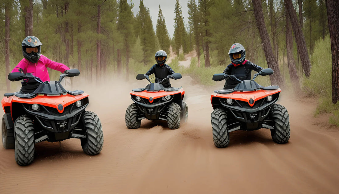 Three riders on orange ATVs driving on a dirt trail through a pine forest.