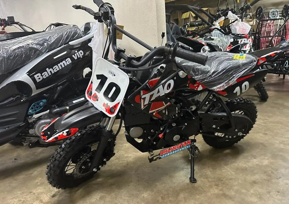 Black and red Tao dirt bike with racing number 10, displayed indoors on a showroom floor.