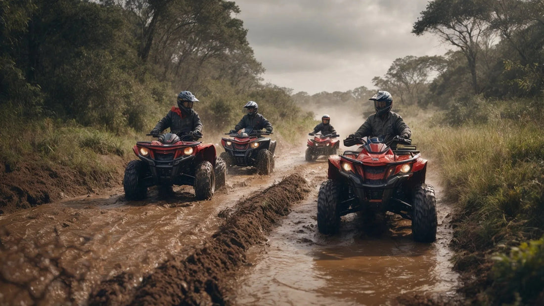 Four people riding red ATVs through a muddy off-road trail in a forested area