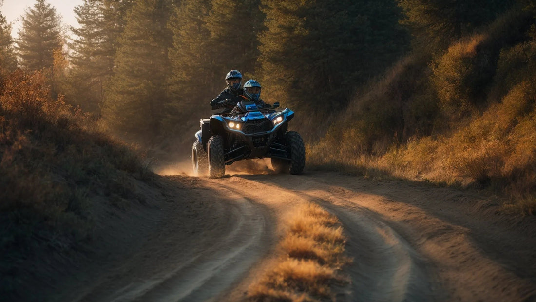 Two riders on an ATV driving on a dirt trail through a forest at sunset