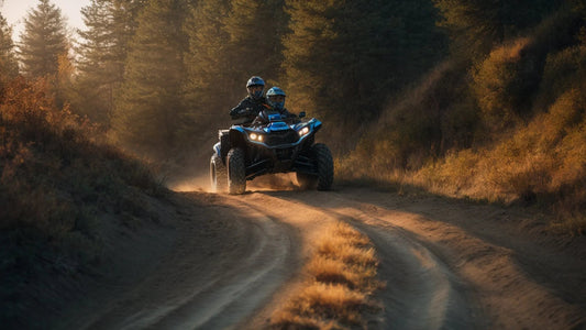 Two riders on an ATV driving on a dirt trail through a forest at sunset
