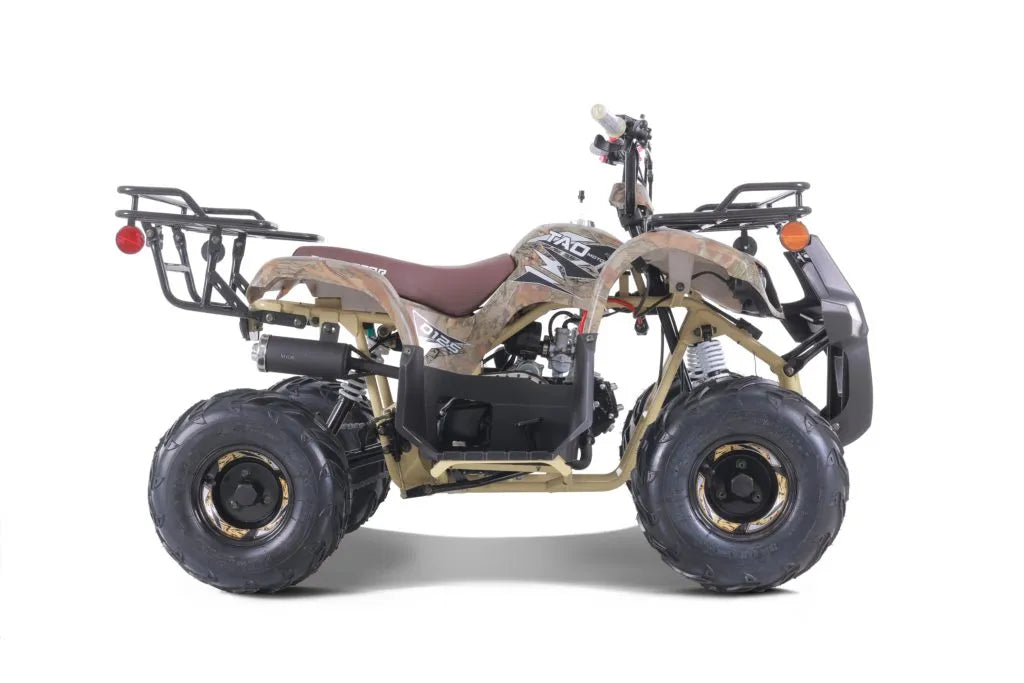Camo youth ATV with rugged tires, front and rear cargo racks on white background