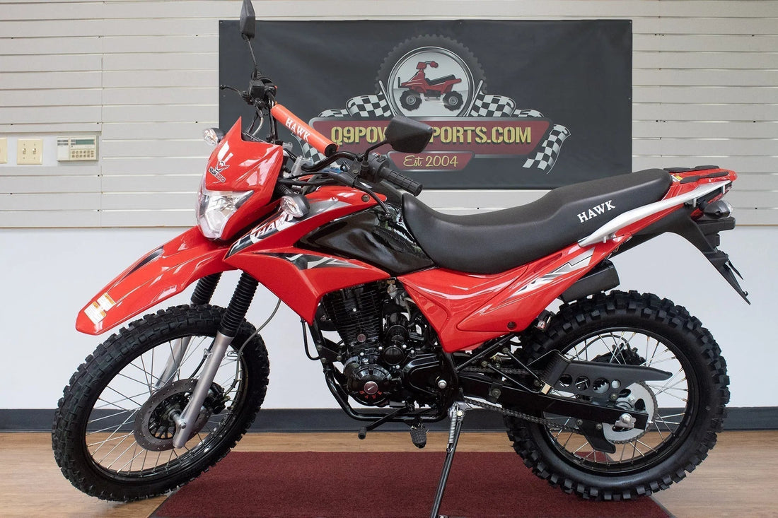 Red Hawk dirt bike with knobby tires on showroom floor, off-road motorcycle display