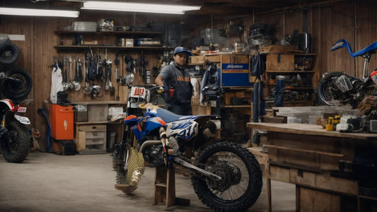 Dirt bike in a workshop with tools and off-road tires, person standing beside bike