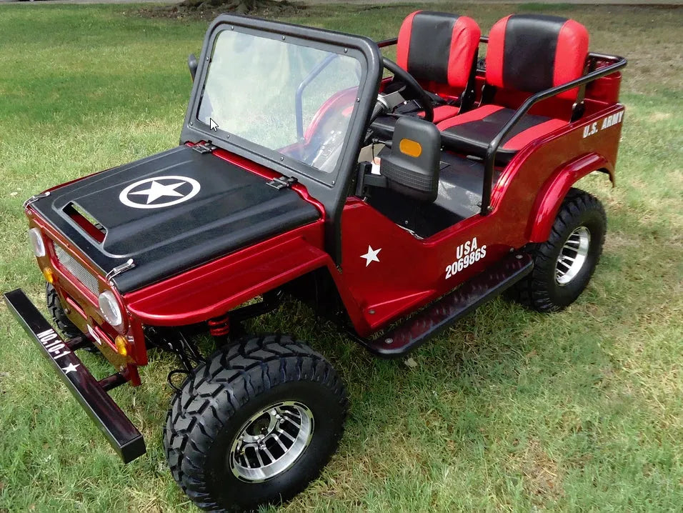 Red mini off-road jeep with black wheels, two seats, military star and U.S. Army decals, parked on grass