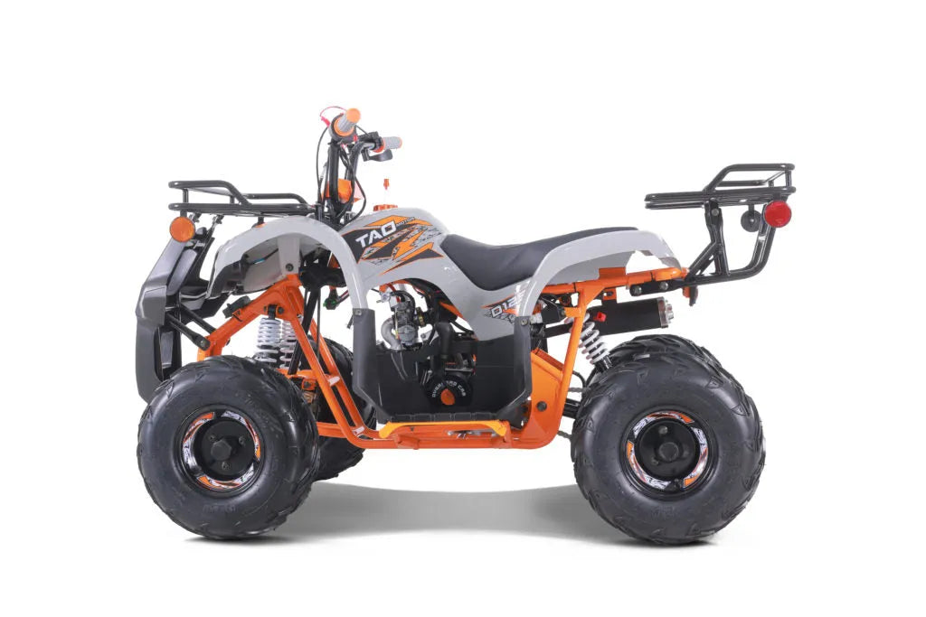 Side view of an orange and white youth ATV with rugged tires and rear cargo racks