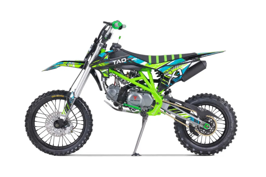 Green and black dirt bike with knobby tires and sporty graphics, side view on white background
