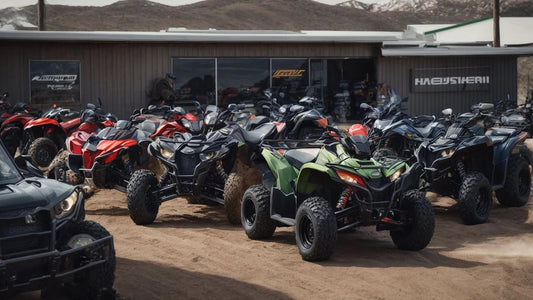 Outdoor lineup of ATVs in various colors parked on dirt in front of a showroom with mountains behind.