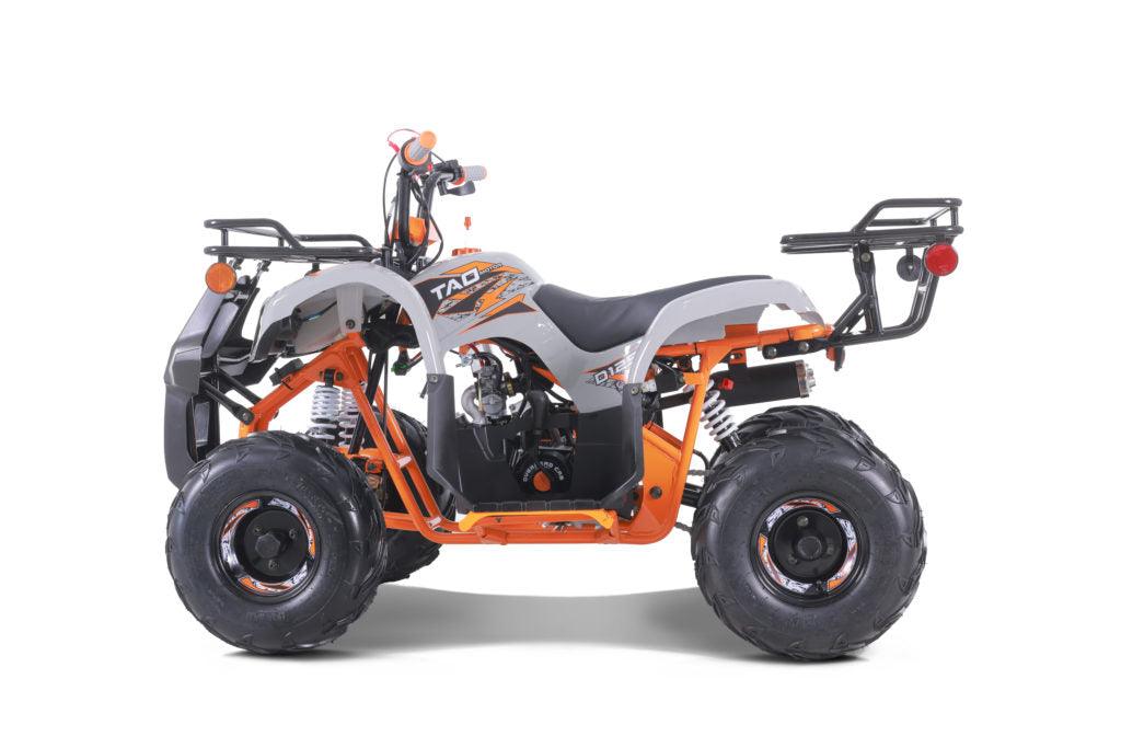 Orange and white youth utility ATV with off-road tires and rear cargo racks, side view