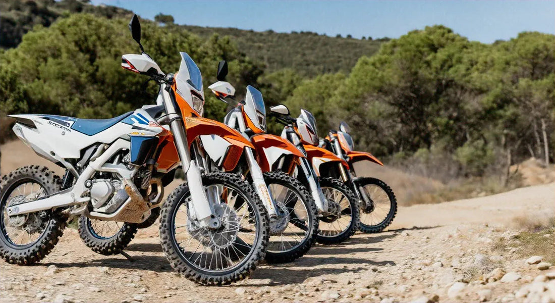 Four orange and white dirt bikes on a rocky trail, outdoors with trees, Q9 PowerSports USA