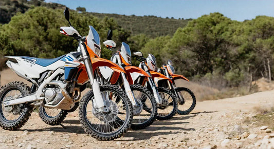 Dirt bikes parked on a rocky trail outdoors, off-road terrain with forest background