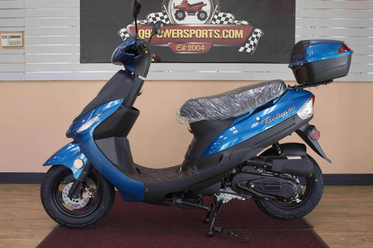 Blue 50cc gas-powered scooter with rear storage box indoors, side profile view