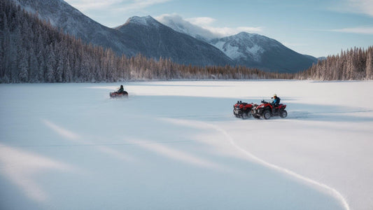 ATVs riding on a snow-covered frozen lake with mountains and pine trees in the background