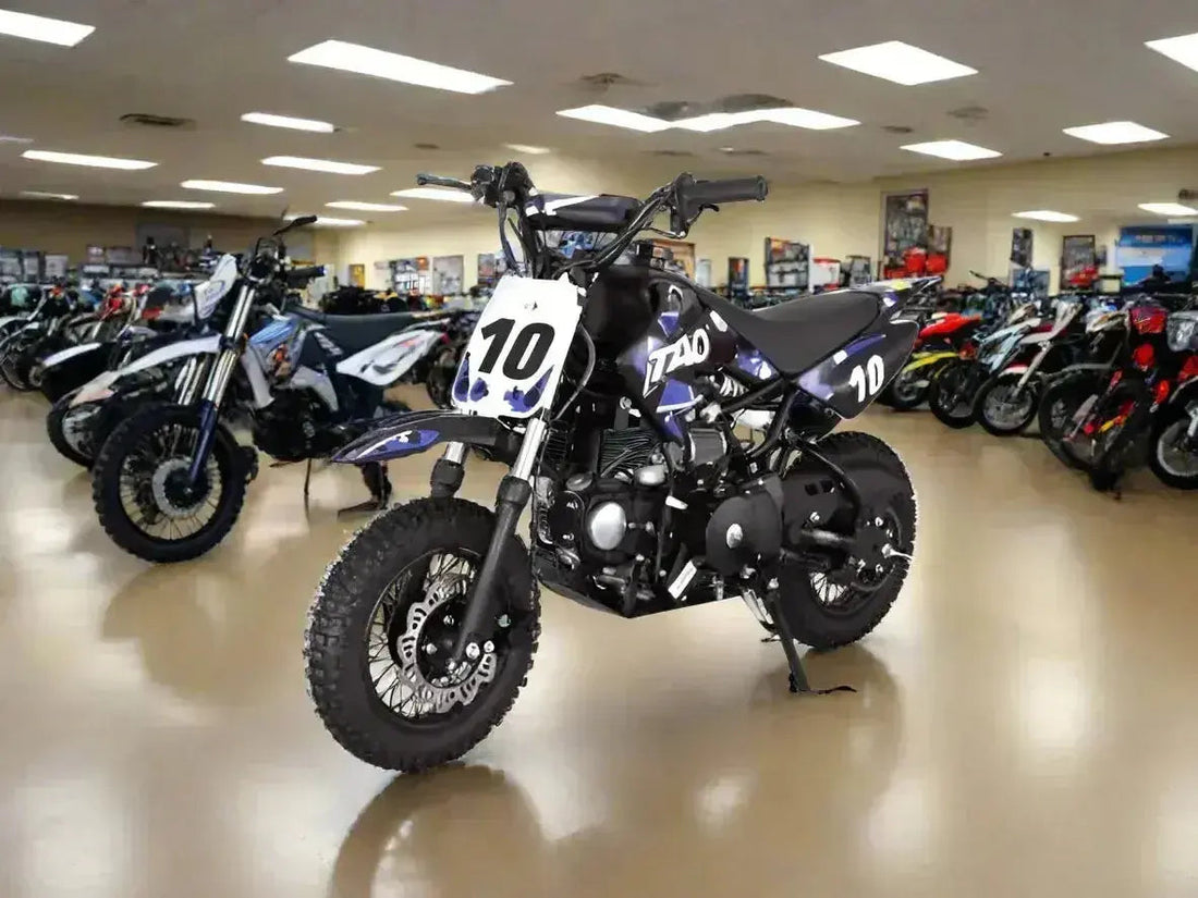 Black Tao dirt bike with number 10 in showroom, surrounded by ATVs and motorcycles