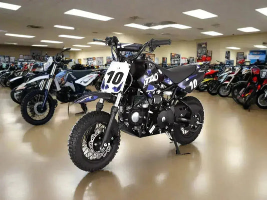 Black Tao dirt bike with number 10 in showroom, surrounded by ATVs and motorcycles