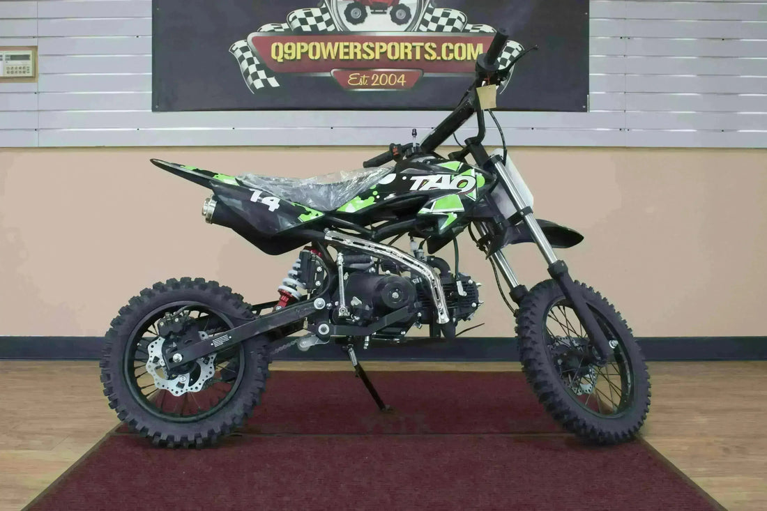 Youth dirt bike with green and black graphics on display at Q9 PowerSports USA showroom