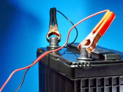 Close-up of battery with red and black charger clamps, battery maintenance concept