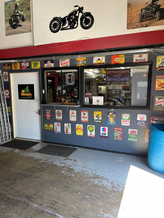 Powersports repair service center entrance with vintage automotive signs and motorcycle decor