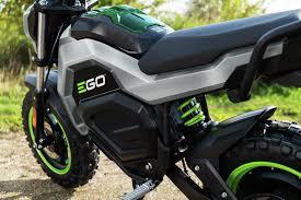 EGO 56V mini bike with green accents parked outdoors on a dirt path